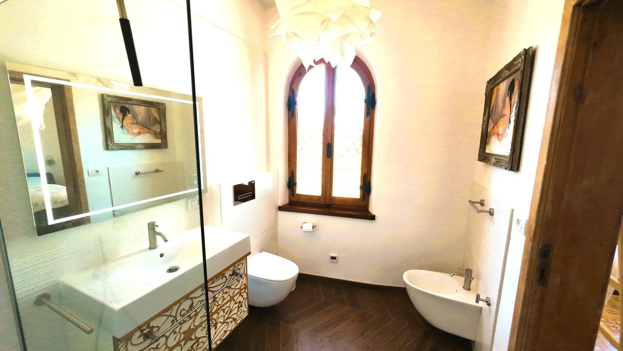Stilvolles Wellness-Ambiente: Modernes Bad mit historischem Bogenfenster und Designer-Sanitäreinrichtungen