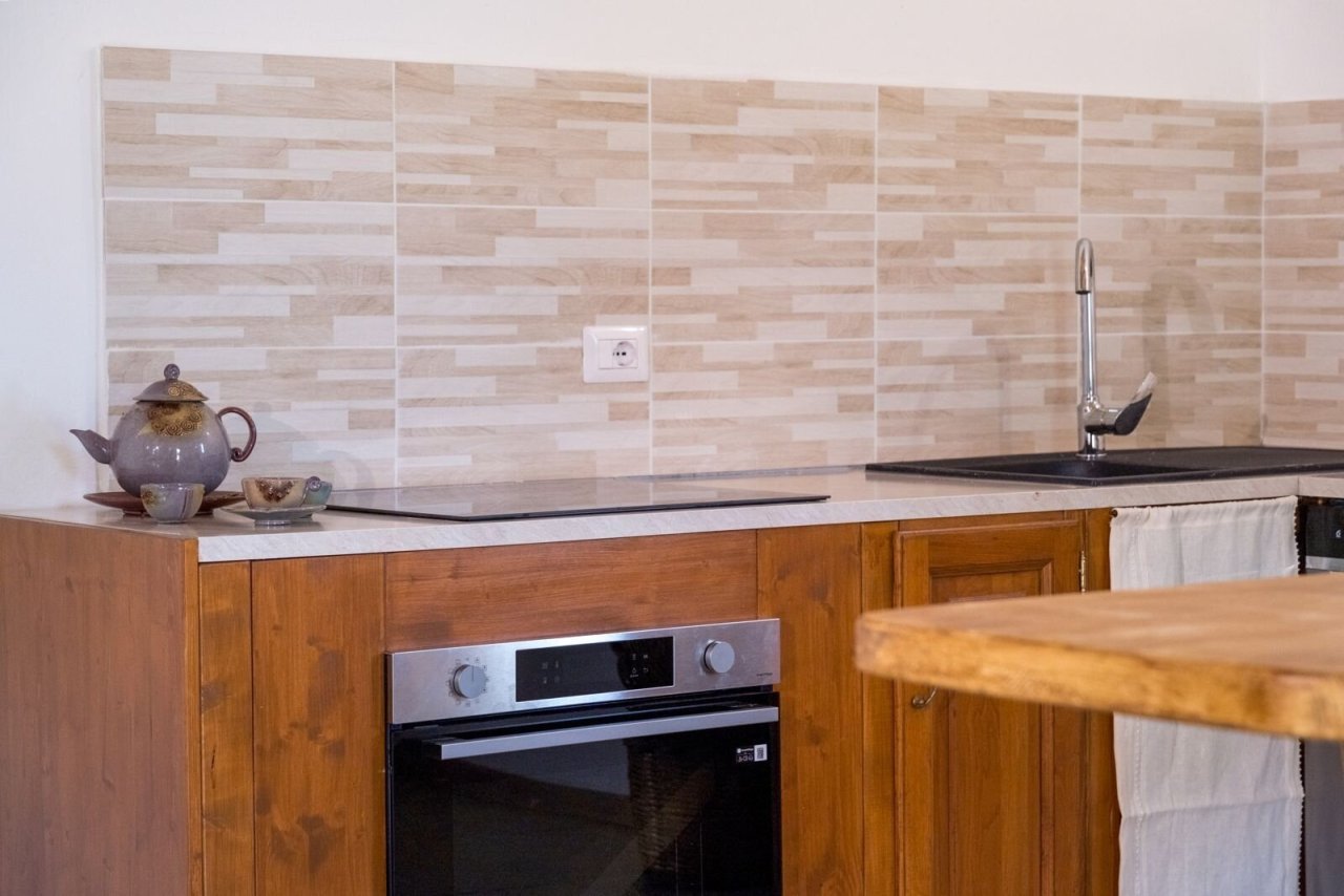 Moderne Landhausküche mit Holzfront und edler Mosaikrückwand - Kochen auf höchstem Niveau!