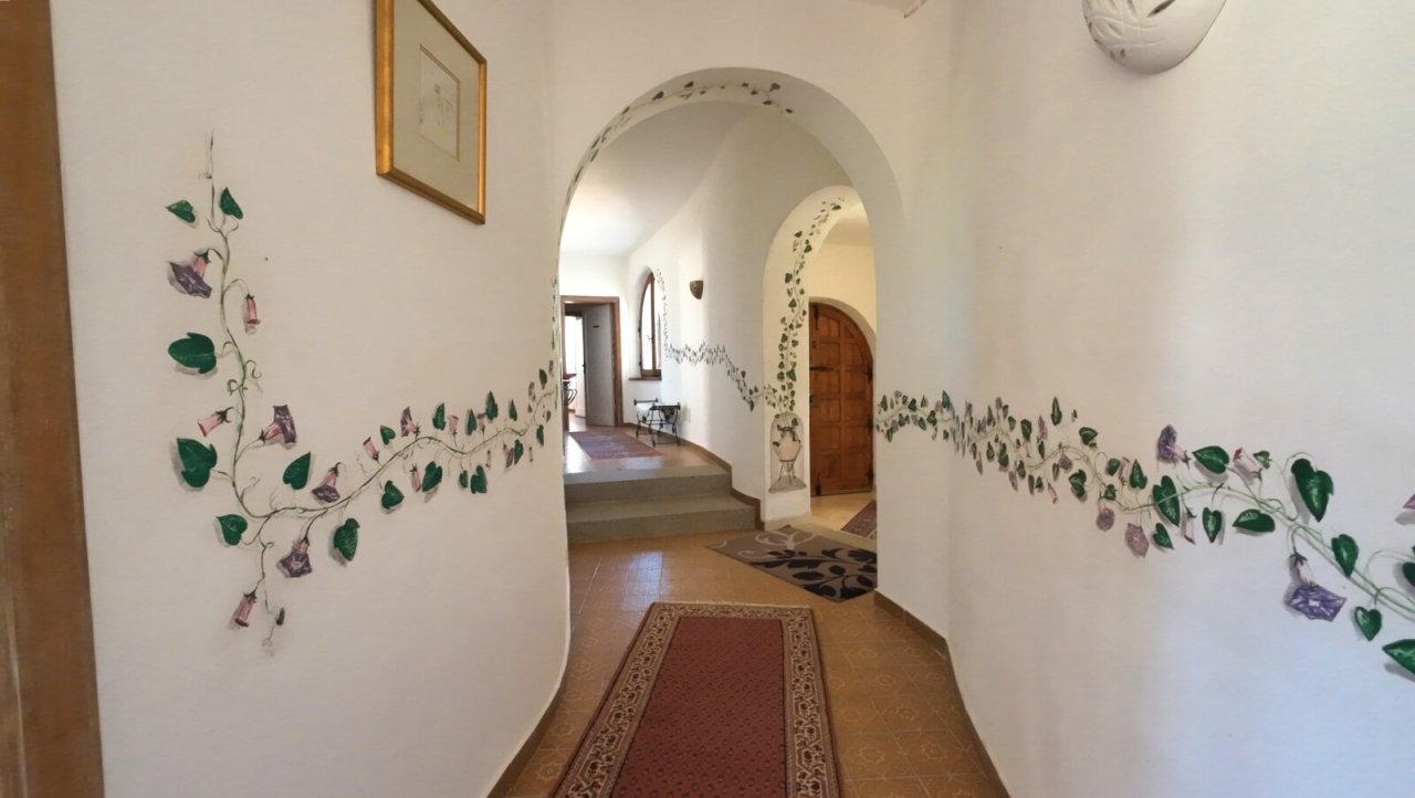 Mediterranean charm: inviting hallway with curved arches and romantic wall painting