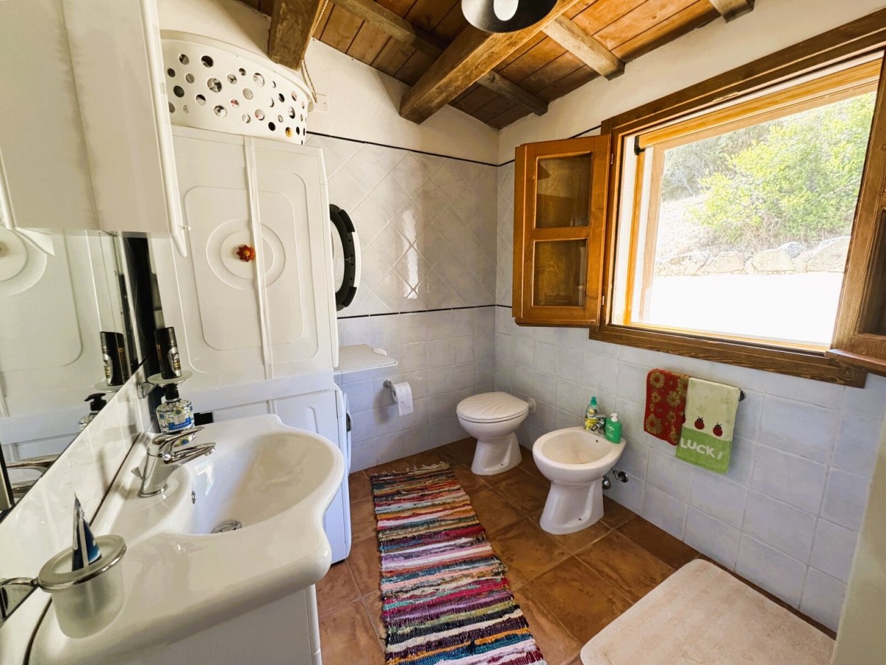 Paradiso rustico del benessere: bagno affascinante con soffitto a travi di legno e vista sulla natura Paradiso rustico del benessere: bagno affascinante con soffitto a travi di legno e vista sulla natura