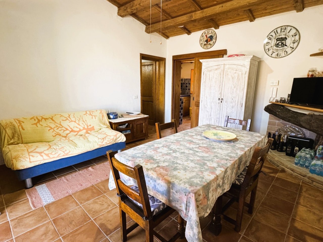Ambiente rustico con charme: zona giorno-pranzo accogliente con soffitto a travi di legno e piastrelle in terracotta Ambiente rustico con charme: zona giorno-pranzo accogliente con soffitto a travi di legno e piastrelle in terracotta