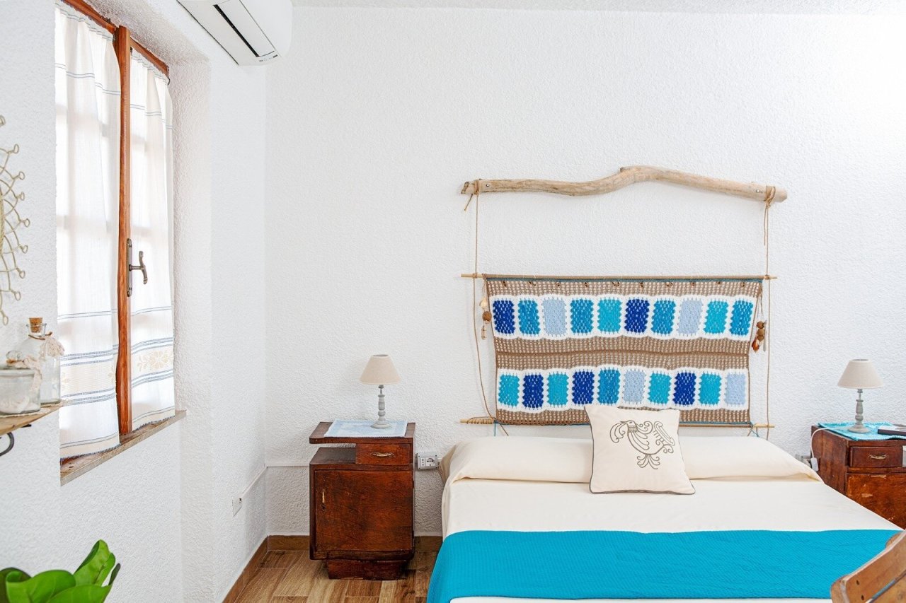 Camera da letto luminosa con soffitti alti e grandi finestre
