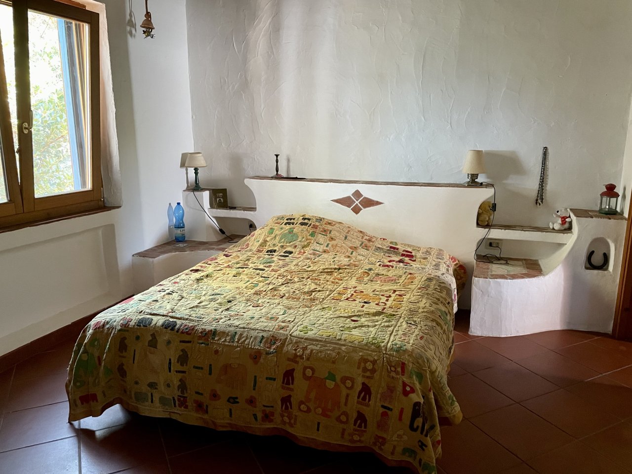 Camera da letto con design integrato della testiera: nicchie funzionali e ripiani incorporati, inclusa inserto decorativo in mosaico Camera da letto con design integrato della testiera: nicchie funzionali e ripiani incorporati, inclusa inserto decorativo in mosaico