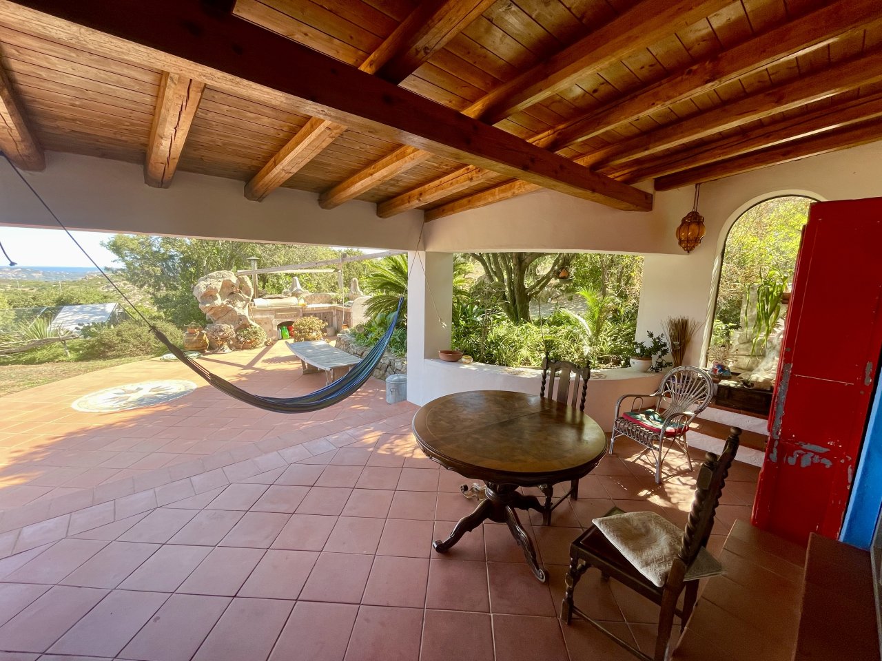 Oasi di benessere mediterranea: terrazza coperta con fascino in pietra naturale e vista sul verde Oasi di benessere mediterranea: terrazza coperta con fascino in pietra naturale e vista sul verde