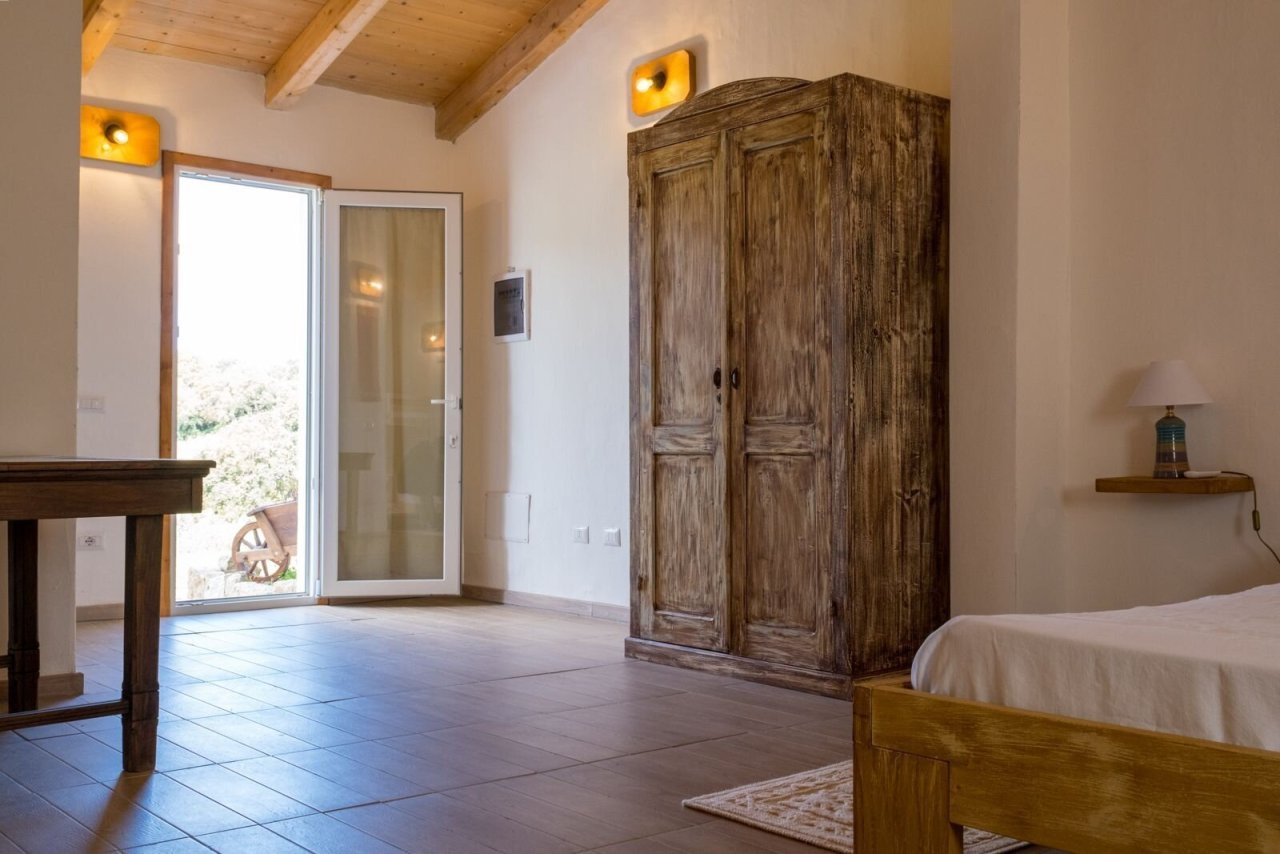 Stanza luminosa con elemento in legno rustico e accesso diretto alla natura